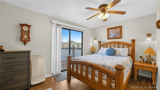 bedroom with baseboards, a water view, a ceiling fan, wood finished floors, and access to exterior