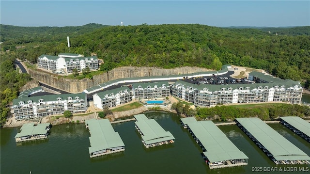 birds eye view of property with a water view and a wooded view