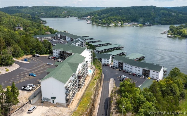birds eye view of property featuring a wooded view and a water view