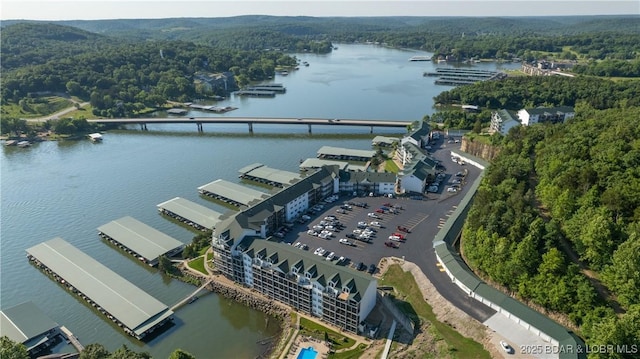 drone / aerial view featuring a water view and a forest view