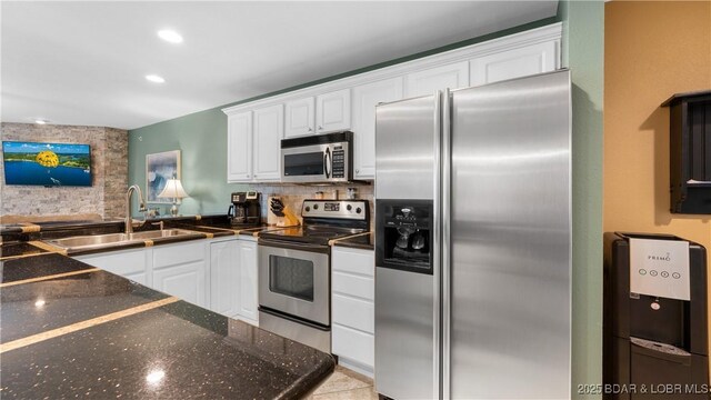 364 Cedar Heights Dr Unit 2B, Camdenton, MO 65020 - kitchen featuring stainless steel appliances, white cabinetry, decorative backsplash, recessed lighting, and dark stone counters