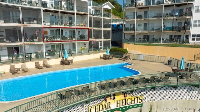 community pool with fence and a patio area