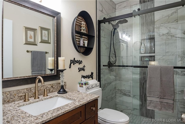 bathroom featuring a stall shower, toilet, and vanity