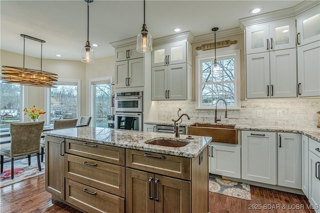 kitchen featuring a sink, double oven, plenty of natural light, a center island, and recessed lighting