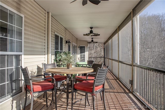 sunroom / solarium featuring ceiling fan and outdoor dining space