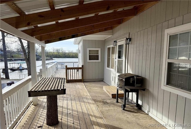 wooden terrace with a water view and a grill
