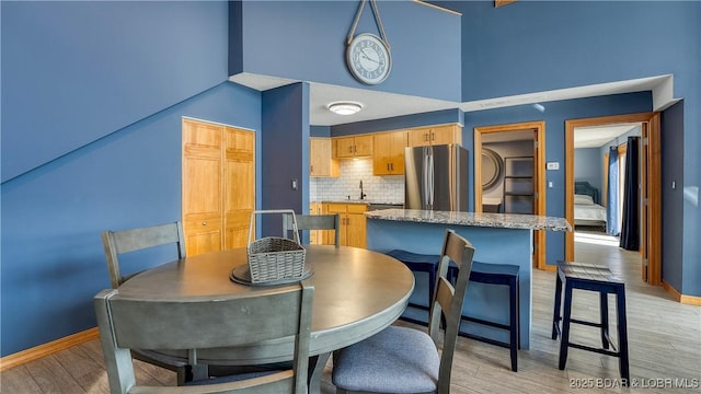 493 Highline Rd, Lake Ozark, MO 65049 - dining space featuring light wood-style floors, baseboards, and a high ceiling