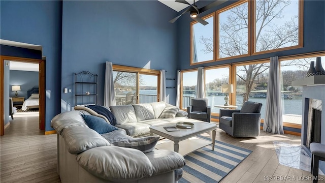 493 Highline Rd, Lake Ozark, MO 65049 - living room with a towering ceiling, ceiling fan, wood finished floors, a water view, and a fireplace