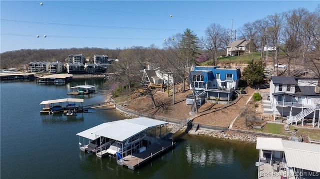 dock area with boat lift, a residential view, and a water view