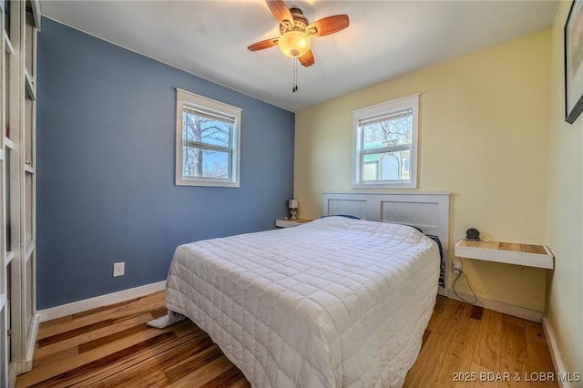 33724 Ivy Bnd, Stover, MO 65078 - bedroom with multiple windows, wood finished floors, and a ceiling fan