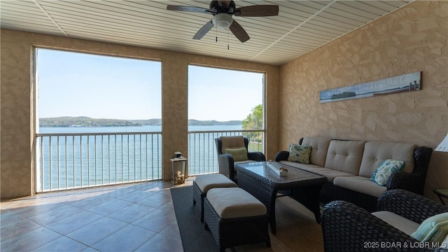 interior space featuring a water view, a ceiling fan, and wallpapered walls
