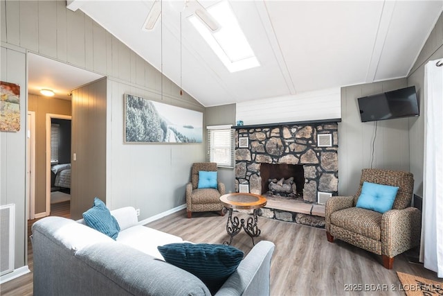 29829 Sheldy Dr, Rocky Mount, MO 65072 - living area featuring vaulted ceiling with skylight, baseboards, wood finished floors, and a fireplace