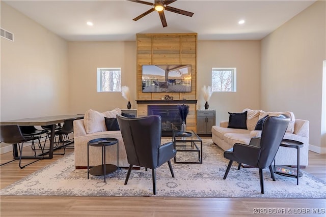 613 Cove Cir, Sunrise Beach, MO 65079 - living area with a fireplace, healthy amount of natural light, ceiling fan, wood finished floors, and recessed lighting