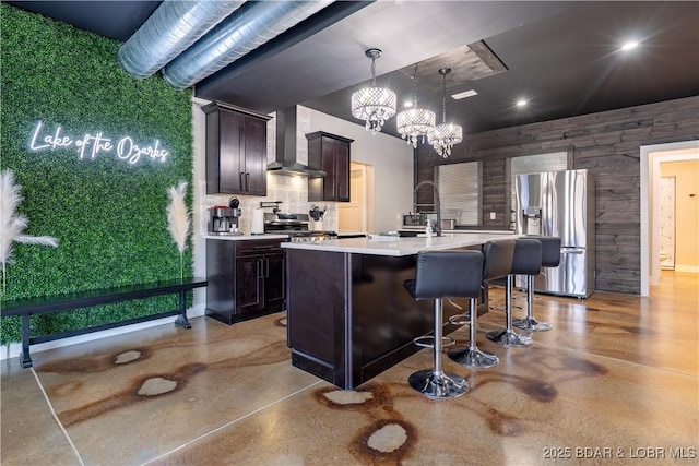 613 Cove Cir, Sunrise Beach, MO 65079 - kitchen with wall chimney range hood, stainless steel fridge with ice dispenser, light countertops, a chandelier, and tasteful backsplash