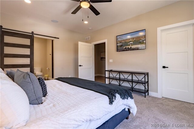 613 Cove Cir, Sunrise Beach, MO 65079 - bedroom with a barn door, carpet, baseboards, connected bathroom, and ceiling fan