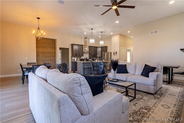 613 Cove Cir, Sunrise Beach, MO 65079 - living room featuring a ceiling fan, baseboards, light wood-style flooring, a chandelier, and recessed lighting