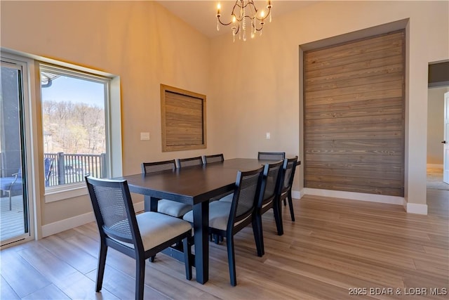 613 Cove Cir, Sunrise Beach, MO 65079 - dining area with a chandelier, light wood-type flooring, and baseboards