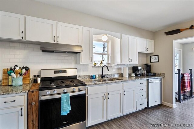 34524 Ivy Bend Rd, Stover, MO 65078 - kitchen with appliances with stainless steel finishes, a sink, under cabinet range hood, and tasteful backsplash