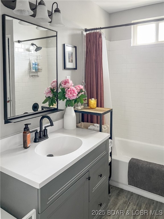 34524 Ivy Bend Rd, Stover, MO 65078 - full bath featuring vanity, shower / bath combo with shower curtain, and wood finished floors