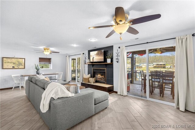 31372 Golden Wood Rd, Gravois Mills, MO 65037 - living room featuring a lit fireplace, wood finished floors, and a ceiling fan