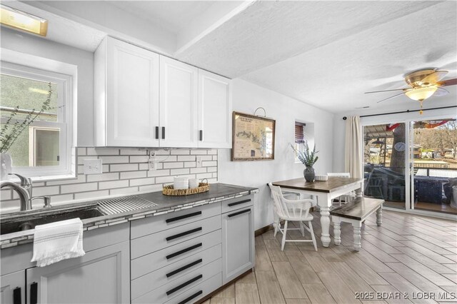 31372 Golden Wood Rd, Gravois Mills, MO 65037 - kitchen with backsplash, white cabinets, ceiling fan, and tile counters
