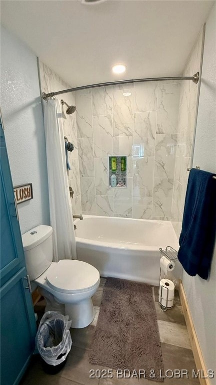 full bath featuring shower / tub combo with curtain, baseboards, and toilet