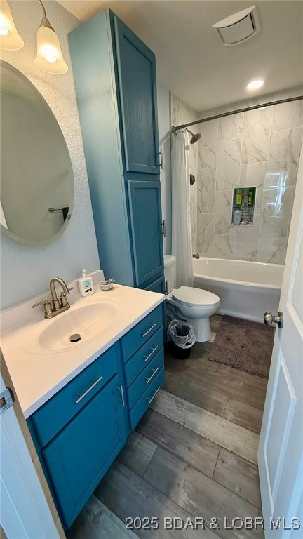 full bathroom with shower / tub combo, vanity, toilet, and wood finished floors