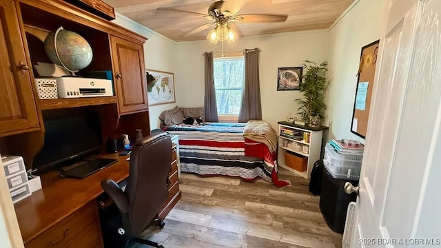 bedroom with hardwood / wood-style flooring, crown molding, and ceiling fan