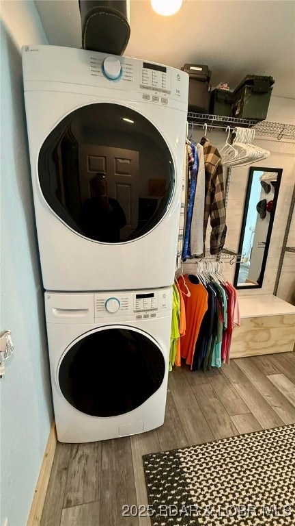 laundry area with stacked washer and dryer, laundry area, and wood finished floors