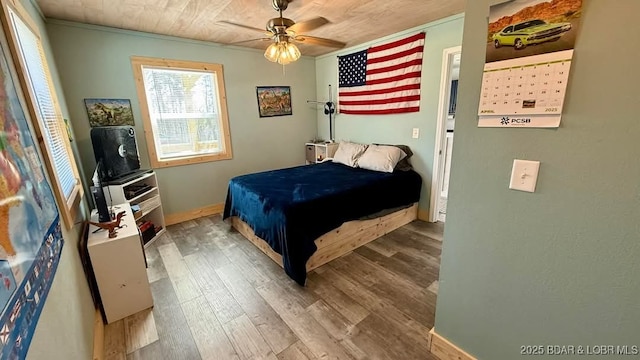 bedroom with baseboards, a ceiling fan, and wood finished floors
