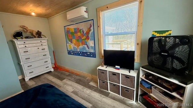 bedroom featuring dark wood finished floors, baseboards, and a wall mounted air conditioner