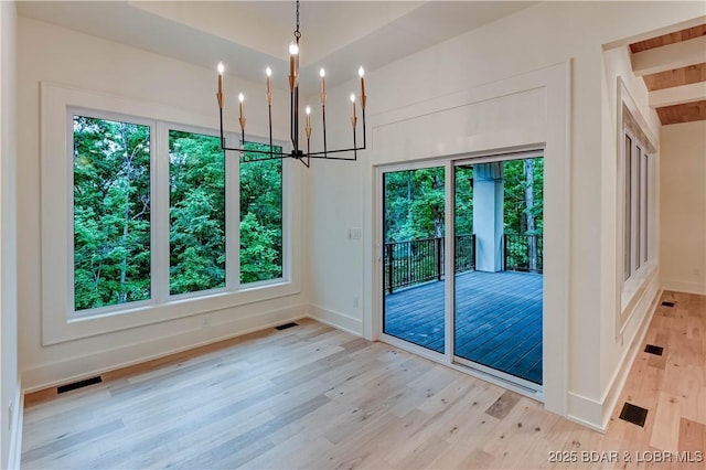 320 Via Appia Dr, Sunrise Beach, MO 65079 - unfurnished dining area featuring light wood finished floors, a chandelier, healthy amount of natural light, and baseboards