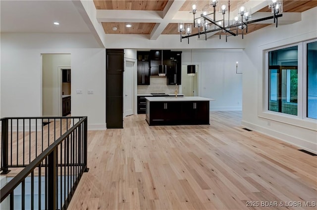 320 Via Appia Dr, Sunrise Beach, MO 65079 - kitchen with light countertops, decorative backsplash, a chandelier, beam ceiling, and light wood-style floors