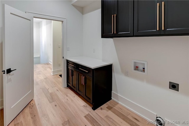 320 Via Appia Dr, Sunrise Beach, MO 65079 - washroom with cabinet space, hookup for an electric dryer, washer hookup, light wood-style flooring, and baseboards