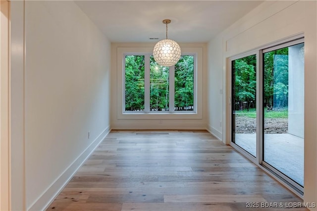320 Via Appia Dr, Sunrise Beach, MO 65079 - unfurnished dining area featuring healthy amount of natural light, light wood-style floors, and baseboards