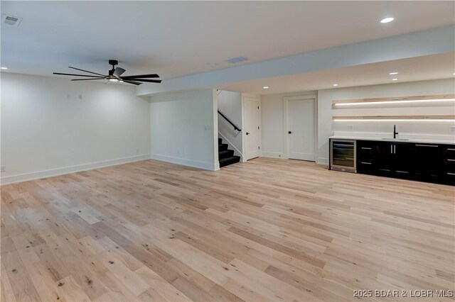 320 Via Appia Dr, Sunrise Beach, MO 65079 - unfurnished living room featuring wine cooler, recessed lighting, stairway, light wood-style flooring, and a sink