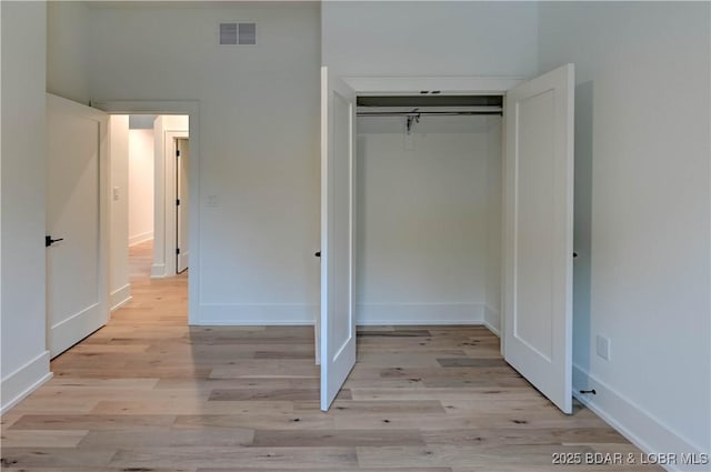 320 Via Appia Dr, Sunrise Beach, MO 65079 - unfurnished bedroom featuring light wood finished floors, a closet, and baseboards