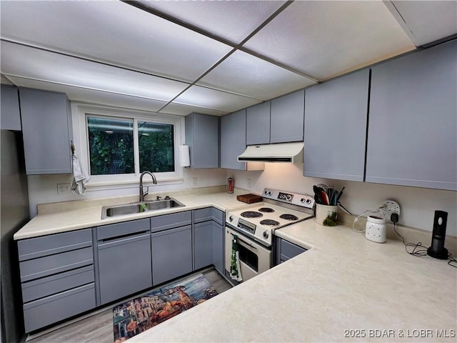 1505 Swiss Village Rd Unit A5, Osage Beach, MO 65065 - kitchen with under cabinet range hood, white electric range oven, gray cabinets, light countertops, and a paneled ceiling