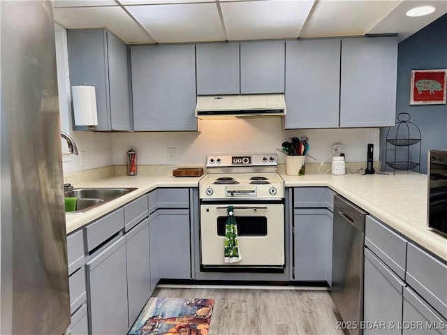 1505 Swiss Village Rd Unit A5, Osage Beach, MO 65065 - kitchen featuring stainless steel appliances, gray cabinetry, ventilation hood, light wood-type flooring, and light countertops