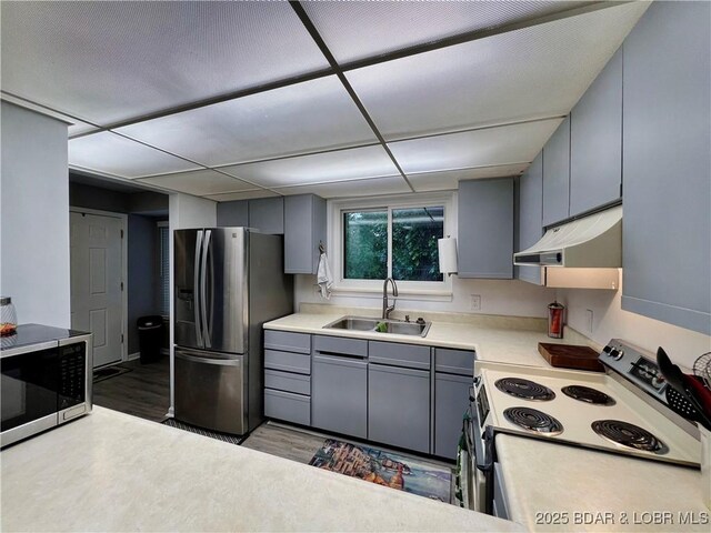 1505 Swiss Village Rd Unit A5, Osage Beach, MO 65065 - kitchen with stainless steel appliances, under cabinet range hood, gray cabinets, and wood finished floors