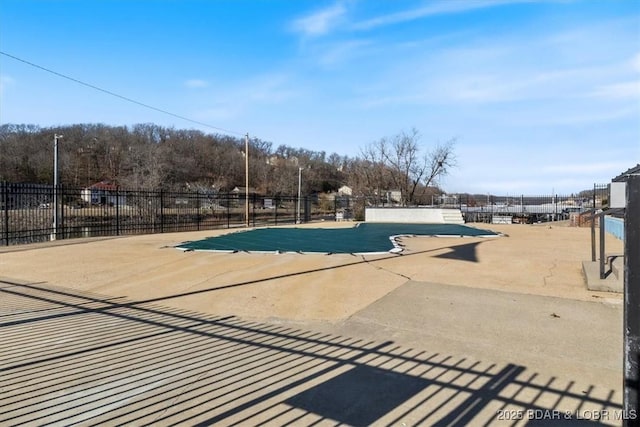 view of swimming pool featuring fence and a patio