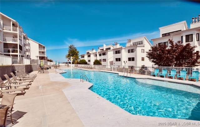 pool with a patio area and fence