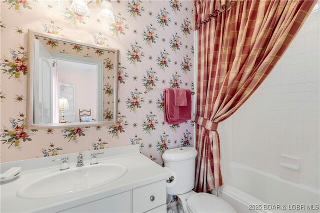 bathroom with wallpapered walls, toilet, vanity, and shower / bathtub combination with curtain