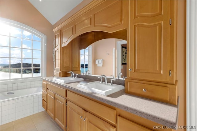 full bath featuring healthy amount of natural light, vaulted ceiling, a relaxing tiled tub, tile patterned flooring, and double vanity