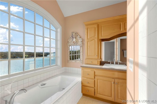 bathroom featuring lofted ceiling, vanity, a bath, a water view, and tile patterned floors