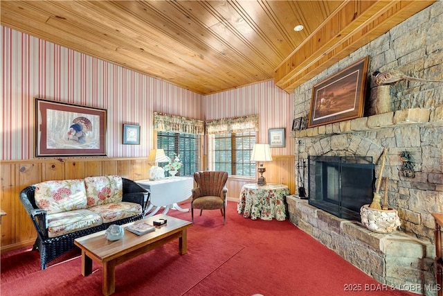 carpeted living area featuring wood ceiling, a fireplace, and wood walls