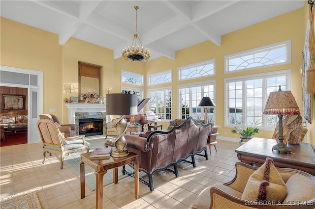 living area featuring light tile patterned floors, a fireplace, beam ceiling, a towering ceiling, and a chandelier
