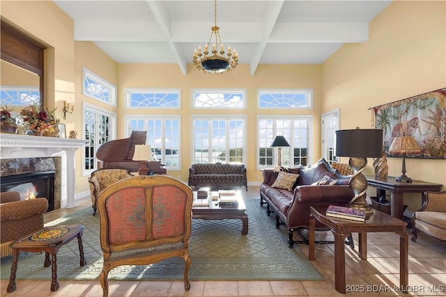 living area featuring beamed ceiling, a fireplace, coffered ceiling, a chandelier, and a towering ceiling