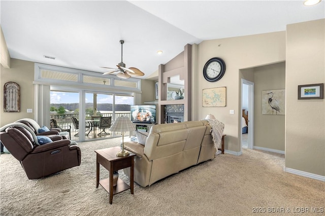 carpeted living room featuring visible vents, baseboards, a tiled fireplace, a ceiling fan, and lofted ceiling