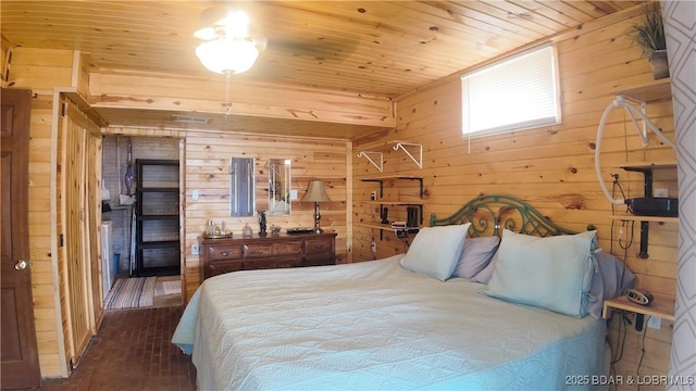 bedroom with wooden walls, brick floors, and wood ceiling